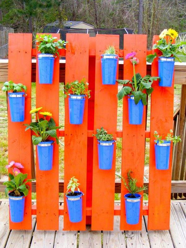 wood euro pallets in the garden using orange and blue flower pots