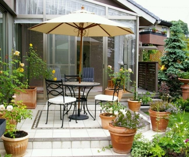 small terrace patio pots flowers wrought iron furniture set screen