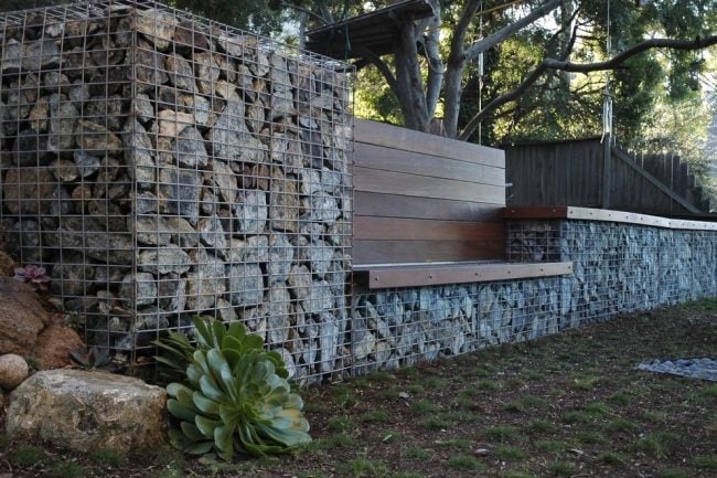 gabion fence itself partly build gabion stones wooden bench