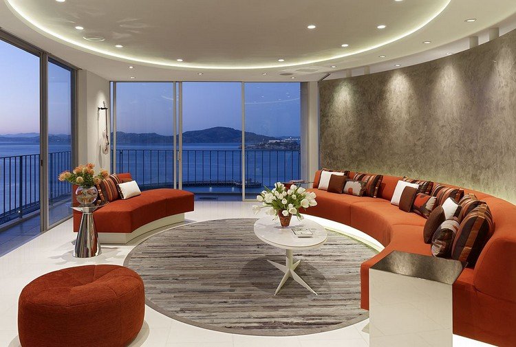 Wohnzimmerbeleuchtung-indirekt-decke-rund-orangenfarbene-sofa-effektfarbe-grau