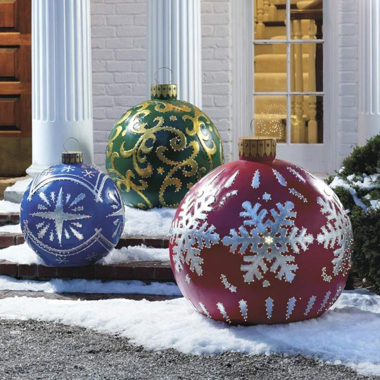 weihnachtsdeko im garten riesig schneeflocken rot silber blau gruen ornamente