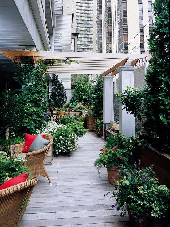 gestaltungsideen-balkon-und-dachterrasse-üppige-bepflanzung-holz-bodenbelag-rattan-möbel