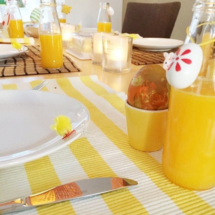 tischdeko-ostern-gelb-weiss-dekorationen-orangensaft-bemalte-eier-eierbecher