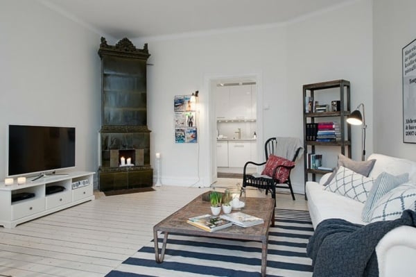 Wohnung skandinavischer Stil Kamin weißer Sofa Regalen