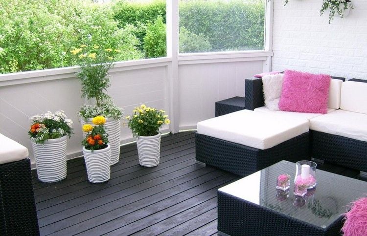 Balkon Gestaltung -rattan-sofa-schwarz-weisse-blumentoepfe-schwarze-dielen