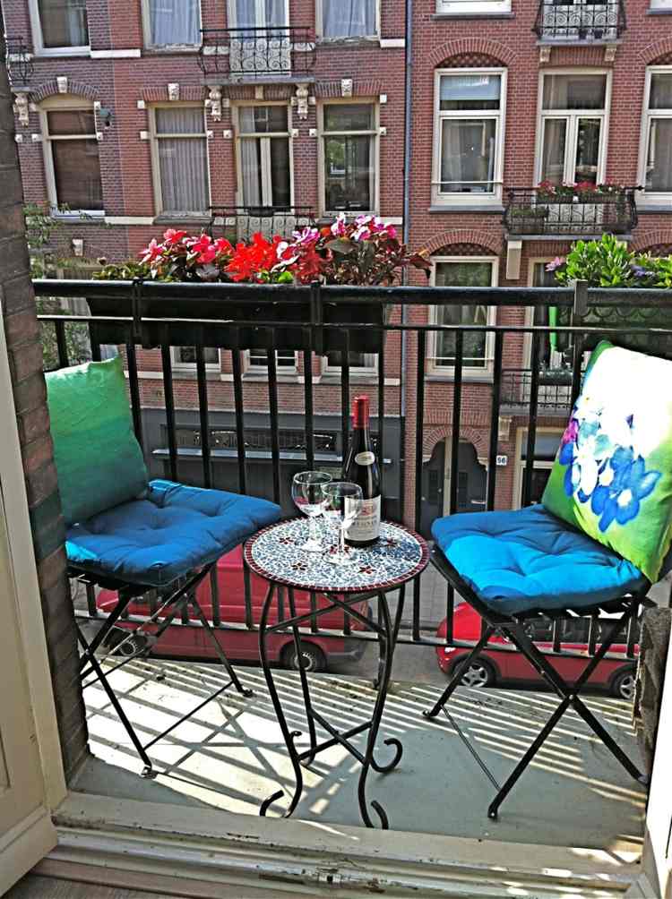 balkon im sommer sitzpolster blau gruen metall moebel gelaender blumenkasten