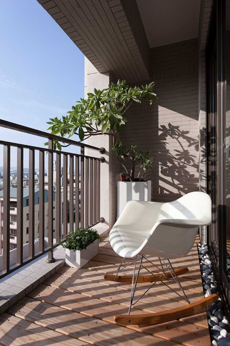 kleinen-balkon-gestalten-ideen-sonnigdielenboden-schaukelstuhl-eames-chair-weiss
