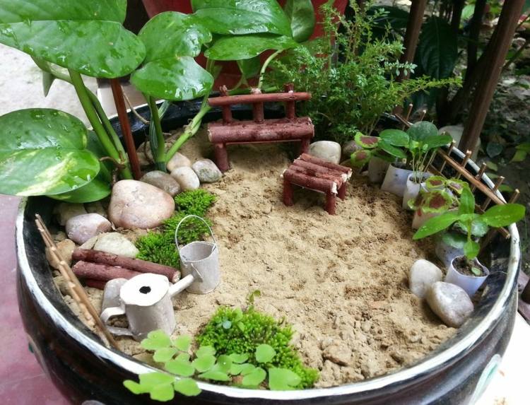 miniaturgärten in pflanzkübeln tropisch flair sand holz sitzbank kieselsteine