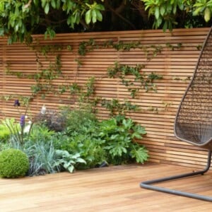 sichtschutz zaun holz material minimalistisch beet pflanzen parkett sitzschaukel