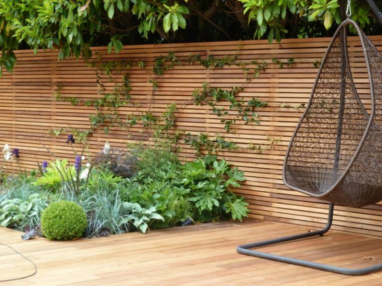 sichtschutz zaun holz material minimalistisch beet pflanzen parkett sitzschaukel