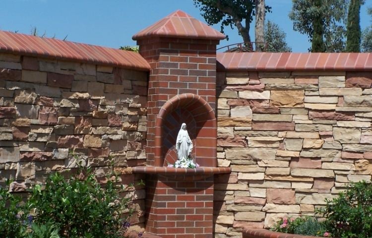 steinmauer im garten saeule backstein maria statue platten