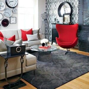 kleine Wohnung neu einrichten rote Sessel schwarze Akzente Tapeten Wanduhren kreative Wandgestaltung