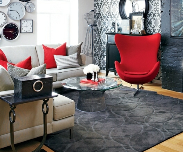 kleine Wohnung neu einrichten rote Sessel schwarze Akzente Tapeten Wanduhren kreative Wandgestaltung