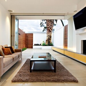 minimalismus-wohnzimmer-beige-bodenfliesen-falttüren