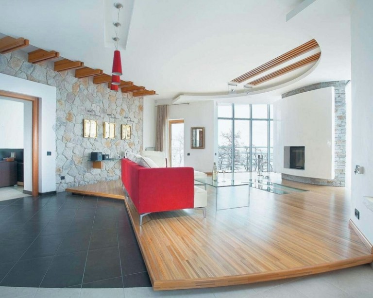 wandgestaltung im wohnzimmer hell stein parkett podest rot sofa