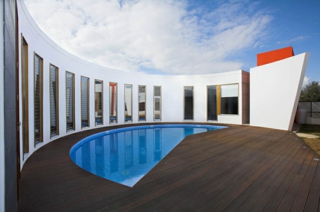 GFK Schwimmbecken teilweise abgedeckt moderne Form Holz Terrasse Haus