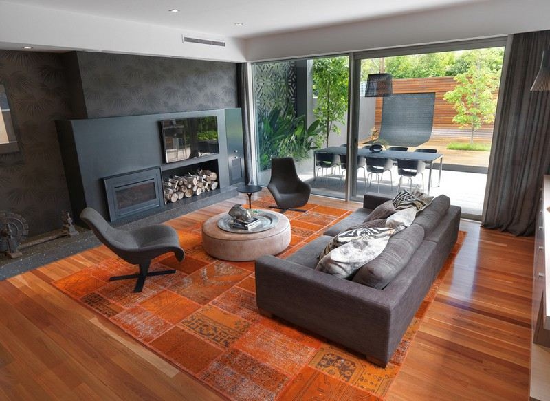 Wohnzimmer-Wohnideen-Design-schwarze-Wand-graues-Polstersofa-Kilim-orange