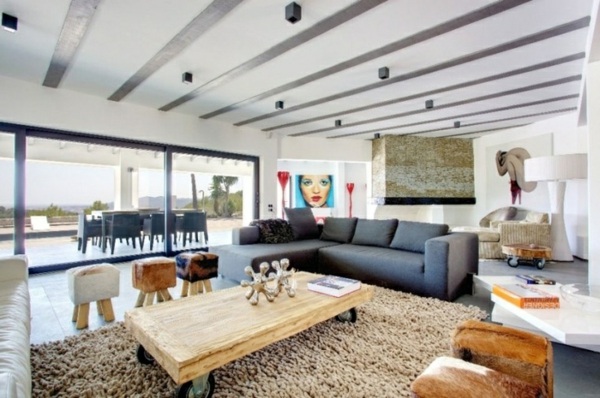 rustikaler Tisch graues Sofa groß Bilder Wand Deko
