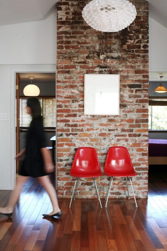 Ziegelmauer Innendesign-rote Stühle-Holzboden-kleine Wohnung einrichten
