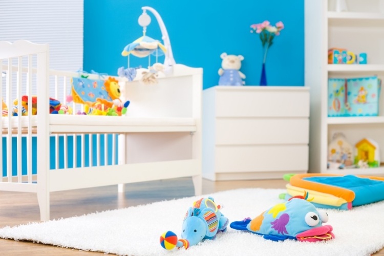 wohnideen-babyzimmer-junge-weiße-moebel-spielzeuge-weicher-teppich-wandfarbe-blau