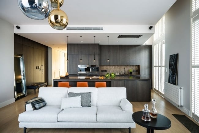 wohnzimmer und küche in einem dunkel weißes sofa orange hocker