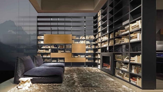 Wohnzimmer Regal Wand System-Bücher Sessel-Teppich flauschig modern