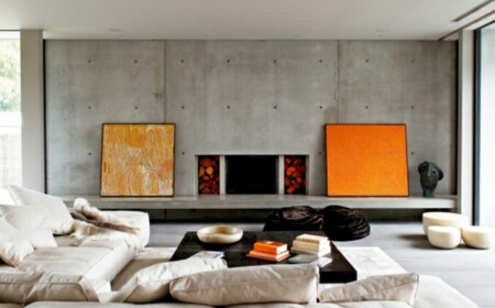 stilvolles Wohnzimmer einrichten orange Akzente Sichtbeton Wand Polstermöbel