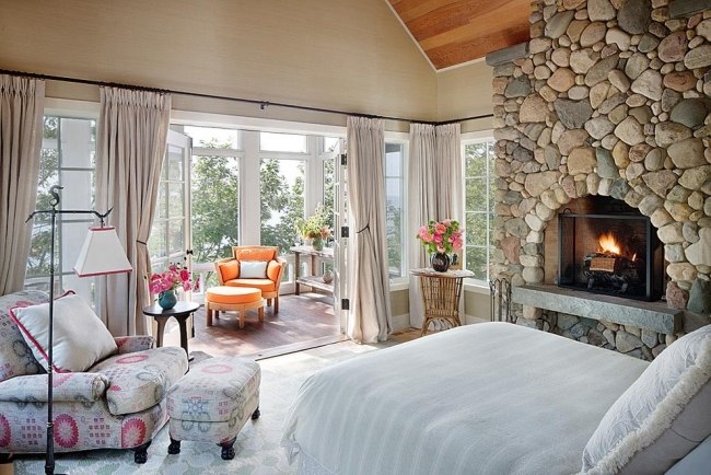 Bett Schlafzimmer-Naturstein Mauer Einbau-Kamin florale Motive orange Sessel michigan-lake Haus