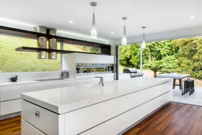 Küche mit Kochinsel weiß glaswände angrenzende terrasse
