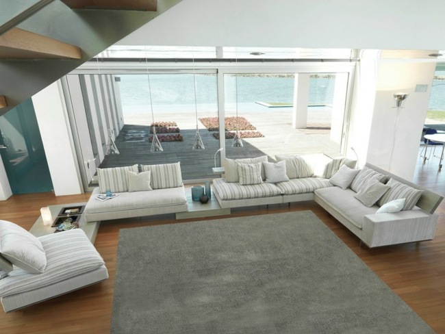 Großes Wohnzimmer mediterranischer Stil weiße Polstermöbel Liegesessel Zweisitzer Sofas