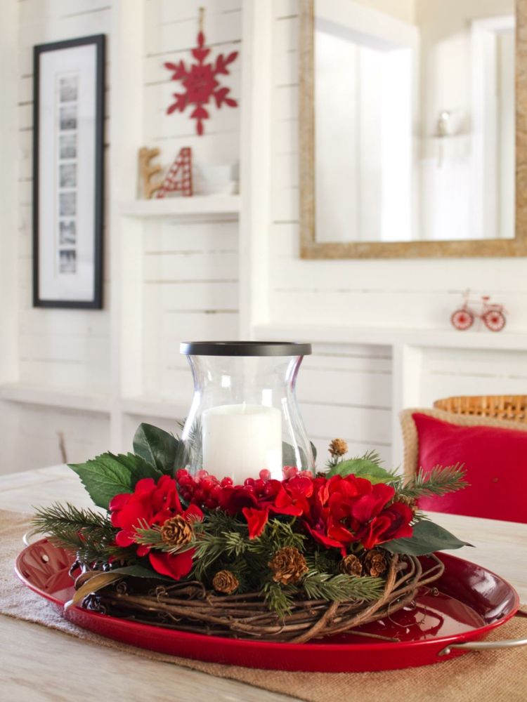 tischdekoration zu weihnachten arrangement rot blumen kerze zweige tannengruen