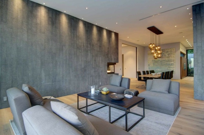 Betonwand subtile Beleuchtung graue Polstermöbel Sofa