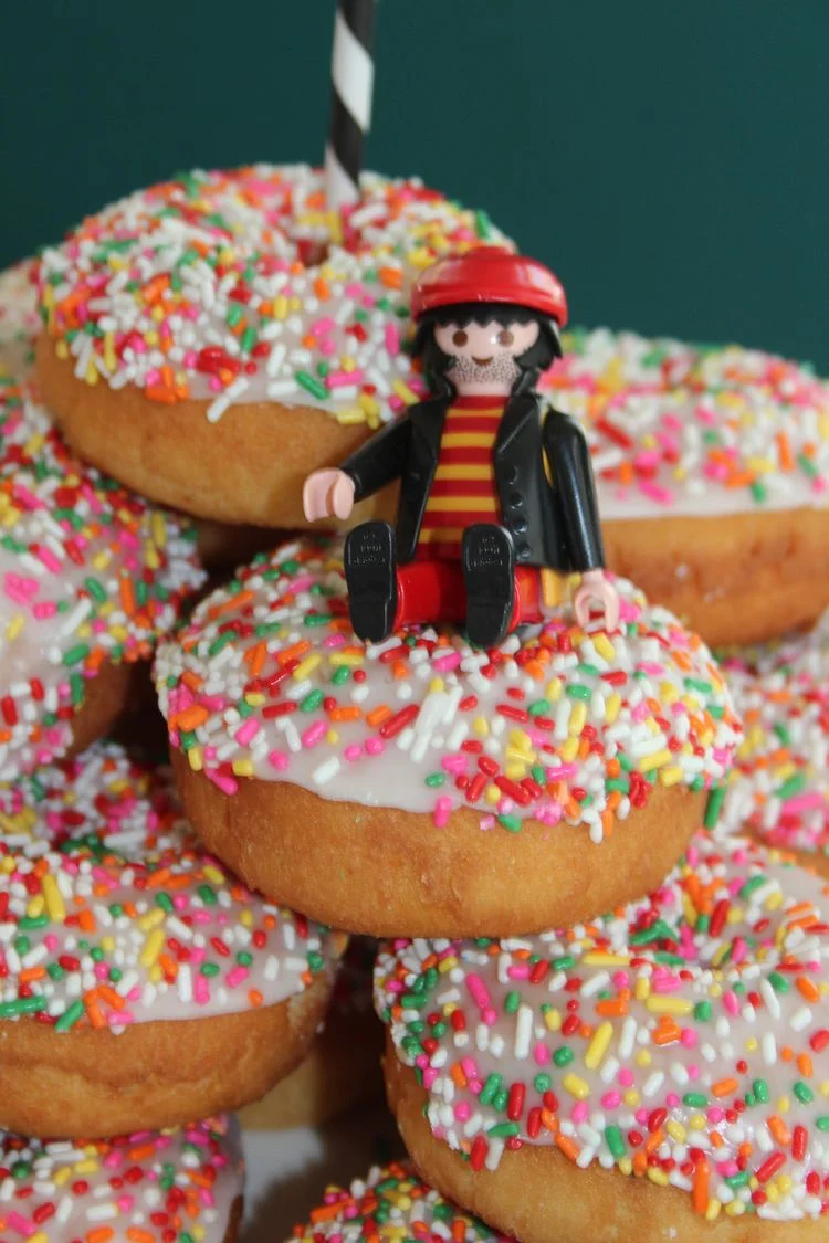 Donuts mit bunten Zuckerstreuseln und Lego Räuber dekoriert
