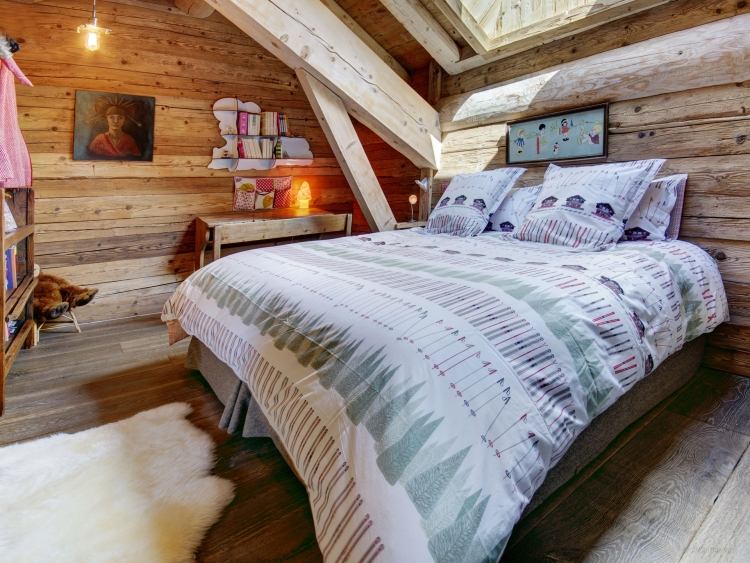 schlafzimmer-einrichtung-stil-chalet-almhaus-holz-massiv-deko-bettwaesche-fellteppich