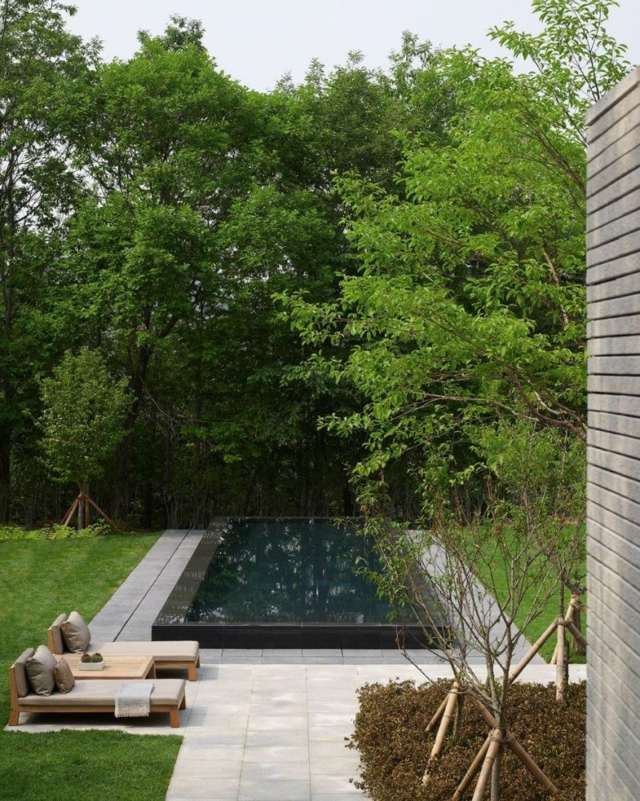 Baum Liegesessel Steinplatten Pool Terrasse