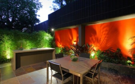 Garten Gestaltung Ideen Hinterhof Beleuchtung begrünter Sichtschutz orange Wand