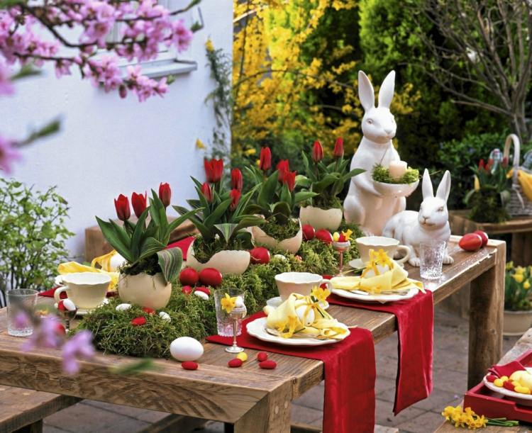 Schöne Tischdeko in Rot und Grün zu Ostern mit Tulpen und Hasen