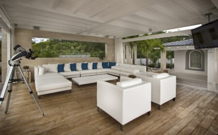 lounge sitzgruppe weiss minimalistisch einrichtung ueberdachung terrasse blau dekokissen
