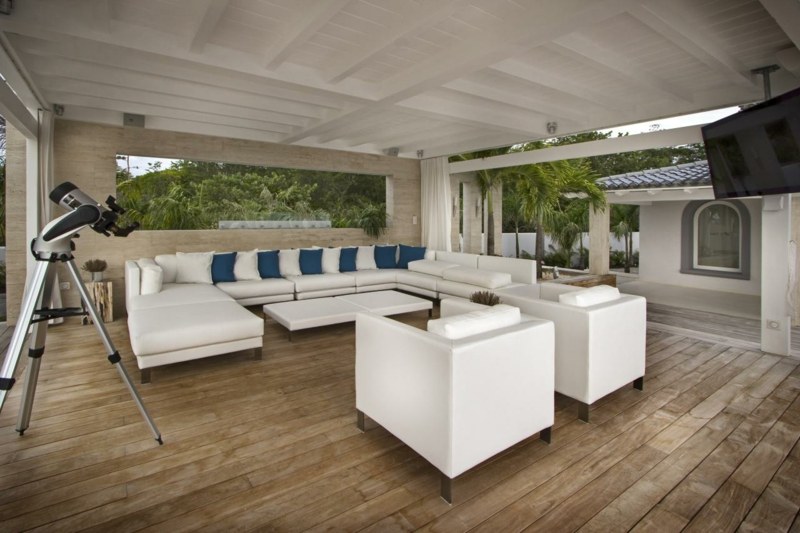 lounge sitzgruppe weiss minimalistisch einrichtung ueberdachung terrasse blau dekokissen