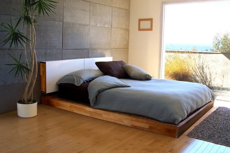 schlafzimmer-idee-modern-design-fenster-holz-palme-bettwaesche-grau-bett boden