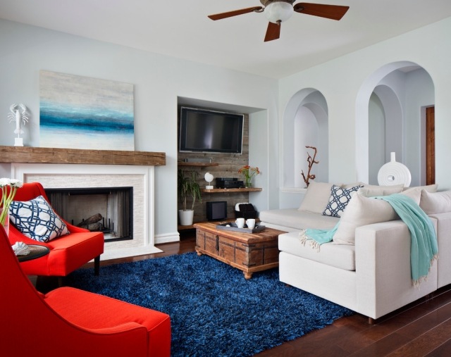 teppich blau shaggy wohnzimmer kamin rote sessel akzente setzen
