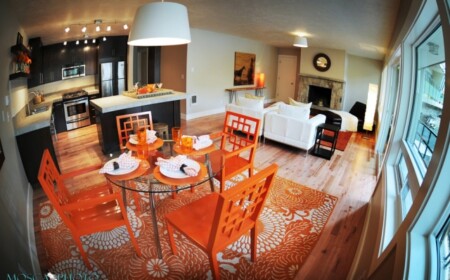 wohnkueche-essbereich-orange-stuehle-teppich-blumenmuster-wohnzimmer-kamin