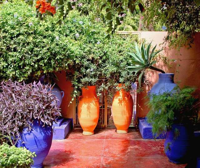 Ideen für Terrassengestaltung frische Blumen Keramik Töpfe gemütliche Sitzecke