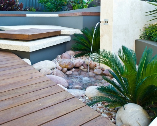 Wasserspiele-Garten klein Becken Steine Palmen Holz Terrasse Bodenbelag