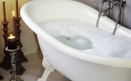 freistehende Badewanne Badarmaturen Teppich Kerzen romantische Stimmung