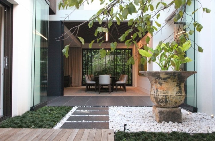 kleingarten-anlegen-minimalistisch-kieselsteine-weiss-gartenweg-grau-steinplatten-bodendecker