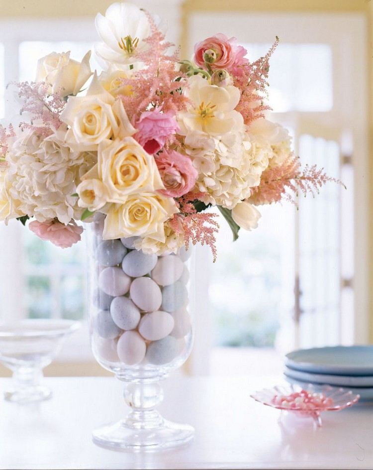Osterdeko mit Blumen glasvase-fuss-gefaerbte-ostereier-pastellfarben