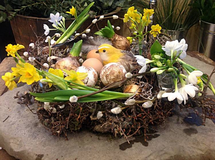 Osterdeko mit Blumen nest-weidenkaetzchen-narzissen-eier-vogelfigur