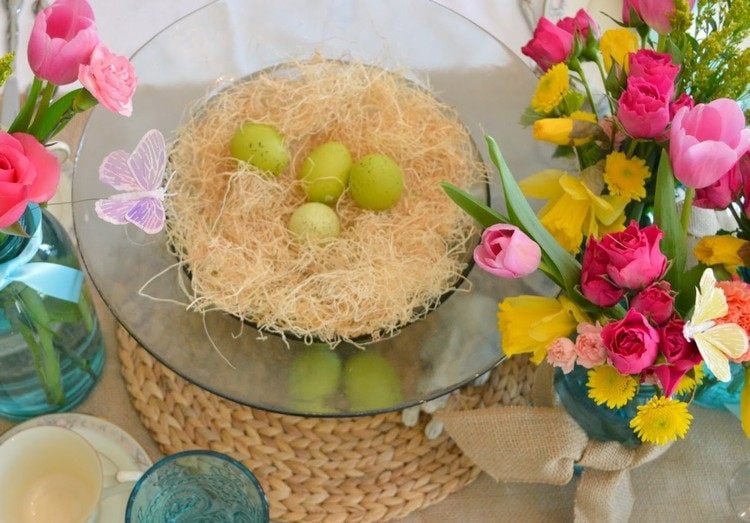 Tischdeko zu Ostern ideen-ostertafel-schmetterlinge-fruehlingsblumen-stroh-nest-wachteleier-rattan-platzset
