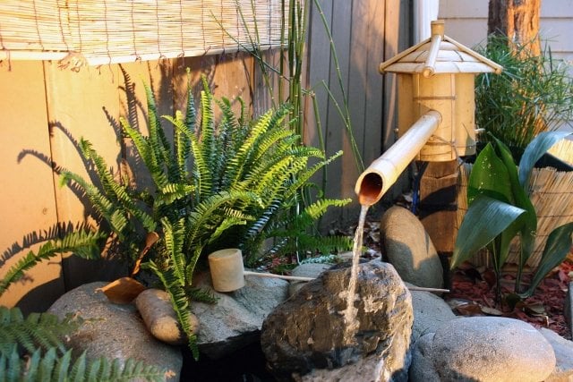 wasserspiel pumpe bambus haus garten steine farnen